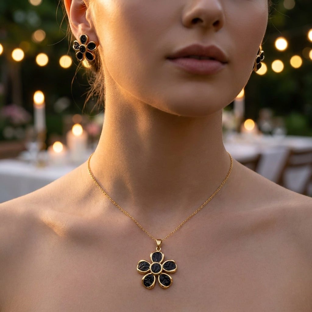 Parure fleur or et email noir - collier et boucles d'oreilles sur marbre