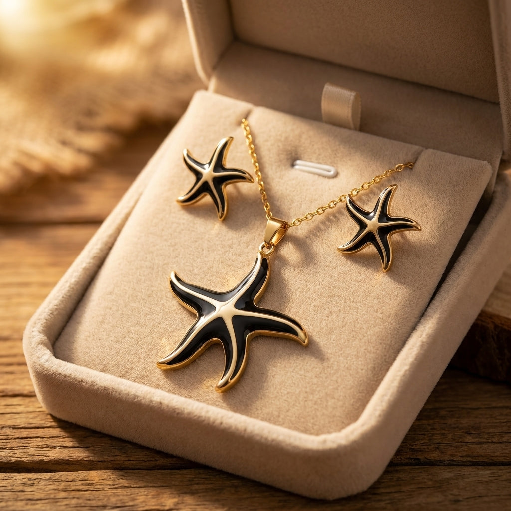 Parure étoile de mer or et émail noir - collier et boucles d'oreilles sur marbre blanc avec eau